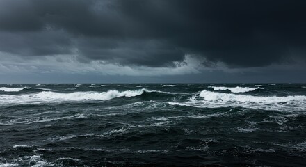 Dramatic seascape with dark stormy clouds over the ocean waves and horizon line