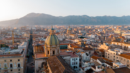 Fototapeta premium Aerial panorama of Palermo, Sicily, revealing the city's dense historic core, domes, and terracotta rooftops framed by surrounding mountains. A vibrant blend of history, culture, and Mediterranean