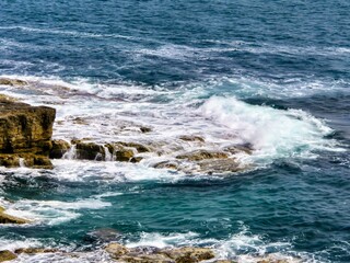 Fototapeta premium Waves Crashing on Rocky Shoreline – Aerial View of Turquoise Sea Foam and Coastal Texture