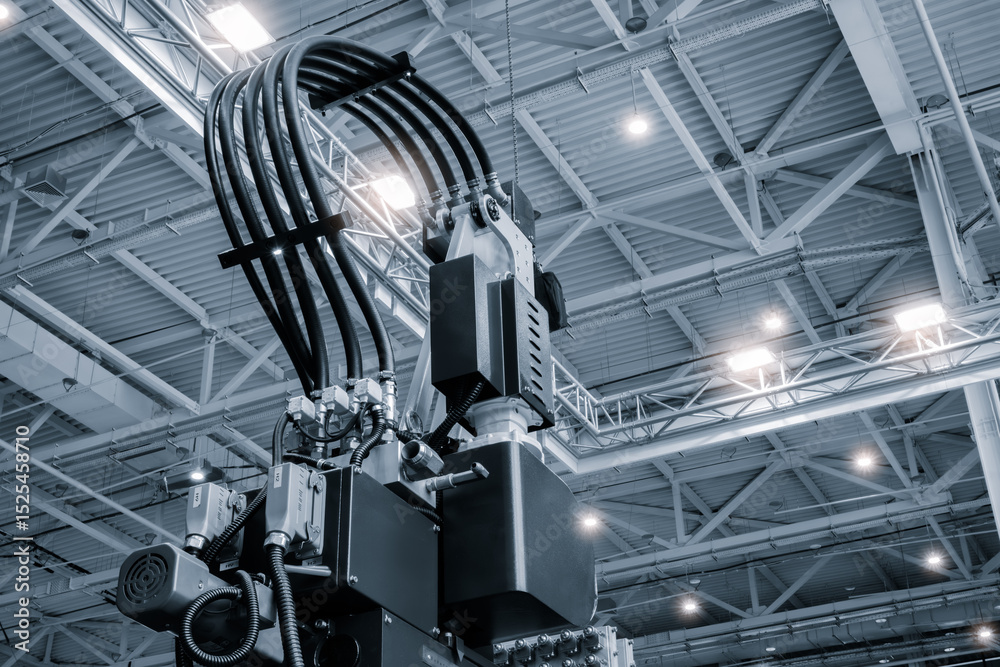 Poster large machine with many wires and tubes is in a large room. machine is surrounded by lights and is v