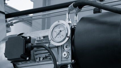 Compressor with pressure gauge mounted on large industrial machine with hydraulic or pneumatic...