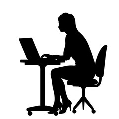 Woman silhouette working on laptop while sitting at a desk  