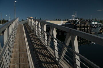 Walking through shadows at gangway in Boat Haven