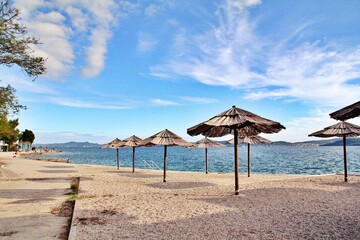 umbrellas on an empty beach, natural umbrellas, sand on the beach, Zadar, Croatia