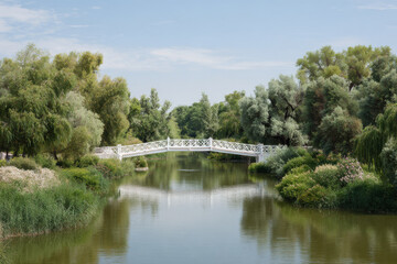 serene landscape of astrakhan featuring beautiful bridge over calm waters surrounded by lush greenery and clear