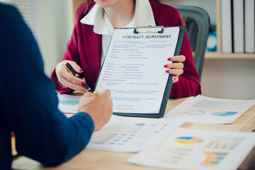 Asian businesswoman, house and condo sales agent, handing over keys to clients and signing sales or rental agreements at office. Real estate business concept.