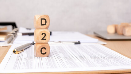D2C letters on wooden cubes stacked on office paperwork