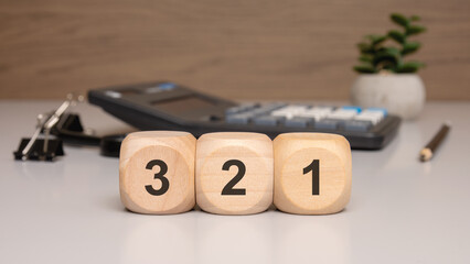 wooden cubes showing numbers 3 2 1 on an office desk