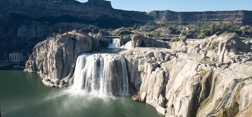 A waterfall is seen in the distance with a rocky shoreline