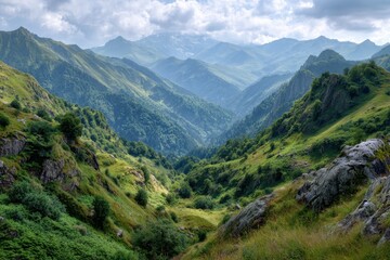 Naklejka premium A scenic view of a valley between green mountains under a cloudy sky during daytime