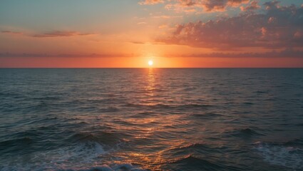 Obraz premium Sunset over the ocean at dusk with vibrant sky colors and calm waves. The scene captures the beauty of the seascape during sunset.