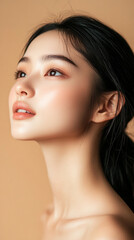 Close-up of a young, beautiful Asian woman with radiant skin, smiling gently against a soft beige background. The image evokes skincare, hydration, and natural beauty, with space for promotional text.