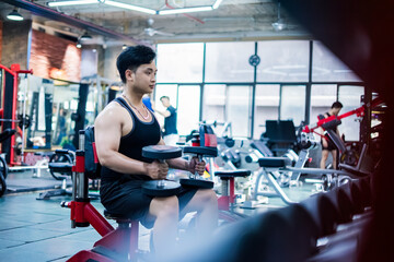 Fototapeta premium Individual engages in strength training with dumbbells in a modern gym during a morning workout session