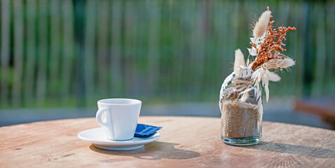 Cup of coffee or espresso placed on a wooden table facing the sea