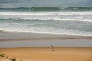 Young girl or teenager walking by the ocean.