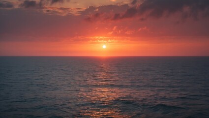 Obraz premium Sunset over the ocean with vibrant colors and calm waters.