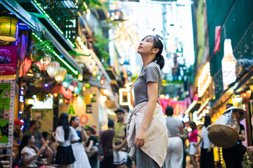 Exploring vibrant street market at dusk with colorful lights and lively atmosphere in an Asian city setting