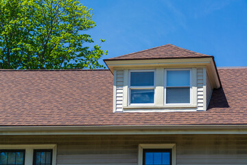Hipped dormer window on the sloped roof of a family house in Brighton, Massachusetts, USA

