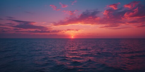 Fototapeta premium Sunset over the ocean with colorful sky and clouds. Natural scene of the sea and sky during evening. The calming horizon at dusk.
