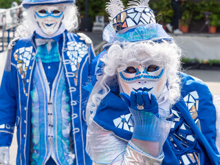Enchanted Carnival Kiss, Dressed in stunning costumes full of mirrors, feathers and blue, the carnival participants exude an aura of fairy tale mystery