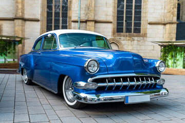 blue and white vintage car on the street of historic town