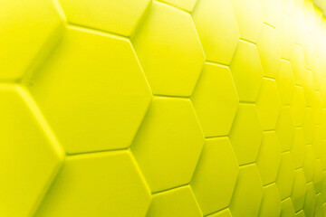 Bright yellow hexagonal tiles create striking textured surface on modern wall, adding touch of...