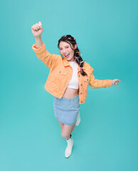 Top view happy young asian teen woman with raised hands celebrating success isolated on blue background.