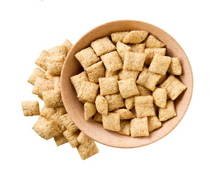 corn pillows pouring out of wooden bowl isolated on white background. Top view.