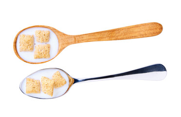 corn pillows with milk in a metal spoon isolated on white background, top view.