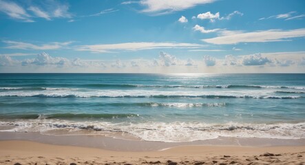 A peaceful beach scene with sand, ocean waves, and a partly cloudy sky. Tranquil coastal landscape. Seaside view with water and sky.