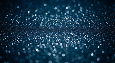A dark blue image features a concentrated band of white and light blue bokeh lights, creating a sparkling, ethereal effect reminiscent of glitter or distant stars.
