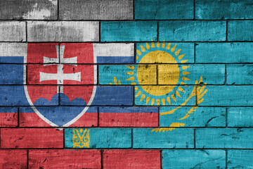 colourful painted big national flag of kazakhstan and flag of slovakia on a massive old brick wall background. concept
