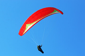 Paraglider flying in a blue sky	