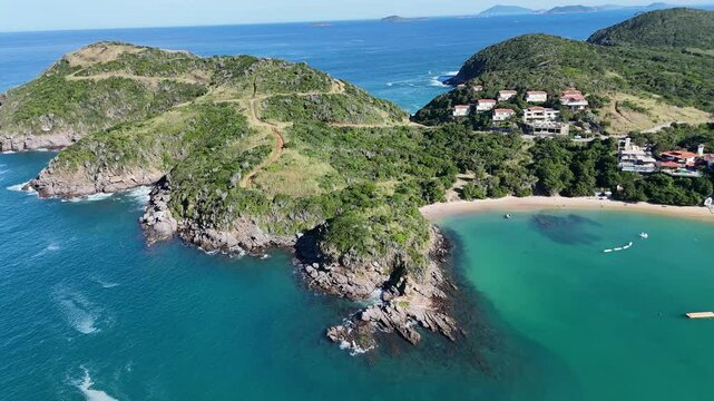 Imagem a&eacute;rea de drone da Praia da Ferradura, em Arma&ccedil;&atilde;o dos B&uacute;zios, Rio de Janeiro, Brasil. Uma enseada de &aacute;guas calmas, cercada por vegeta&ccedil;&atilde;o e casas de alto padr&atilde;o, ideal para turismo e n&aacute;uticos