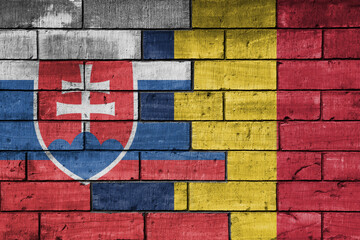colourful painted big national flag of romania and flag of slovakia on a massive old brick wall background. concept