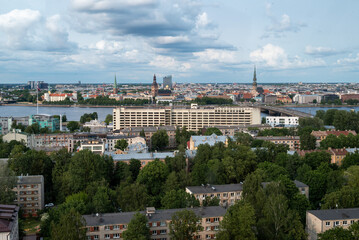Obraz premium Color photograph taken from the Riga Ferris wheel, showing a panoramic view of the city. The image features the historic Old Town with its church spires, the Daugava River glistening in the light.