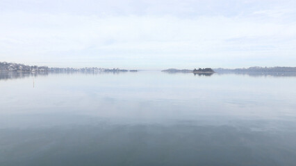 seascape of ocean with land on cloudy day