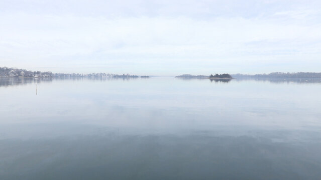 seascape of ocean with land on cloudy day