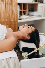 Scalp spa treatment with long dark hair on spa couch, professional hair therapy session