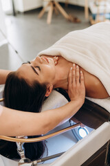Scalp spa treatment with long dark hair on spa couch, professional hair therapy session