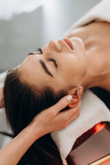 Scalp spa treatment with long dark hair on spa couch, professional hair therapy session