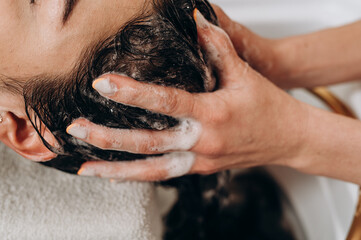 Close‑up spa scalp shampoo foaming on hair during professional scalp treatment