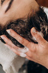 Close‑up spa scalp shampoo foaming on hair during professional scalp treatment