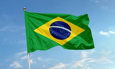 Fototapete Brasilien Brazil national flag with green field, yellow diamond and starry blue globe waving proudly in the clear sky  © Cetin