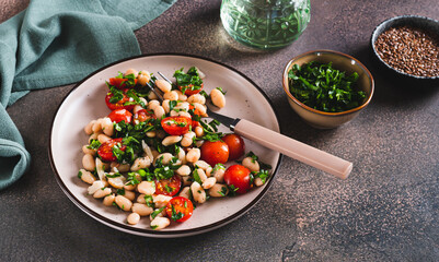 Appetizing salad of white beans, cherry tomatoes and parsley on a plate web banner