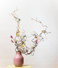 Decorative curly branches in pink ceramic vase.