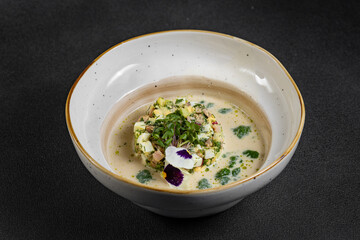 Cold summer soup okroshka. Light soup in a white bowl. 