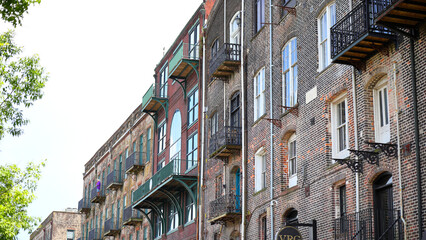 Old southern buildings commercial property with plants and vines growing on brick and old iron balconies. 