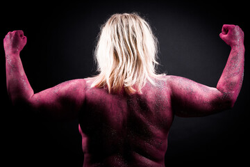 Back view of glitter painted muscular woman.