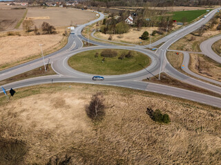 Aerial view of traffic roundabout surrounded by dry fields.